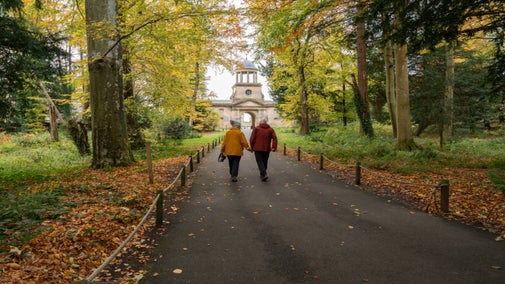 Couple walking towards Wallington Clocktower in autumn